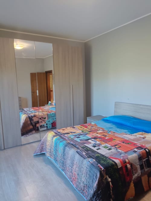 Spacious bedroom at Residenza Montemarcone in Atessa with mirrored wardrobe, blue bedding, and light wood furnishings