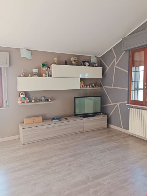 Modern living room in La Rondine apartment, Tales of Abruzzo, Atessa with wall-mounted shelving and flat-screen TV