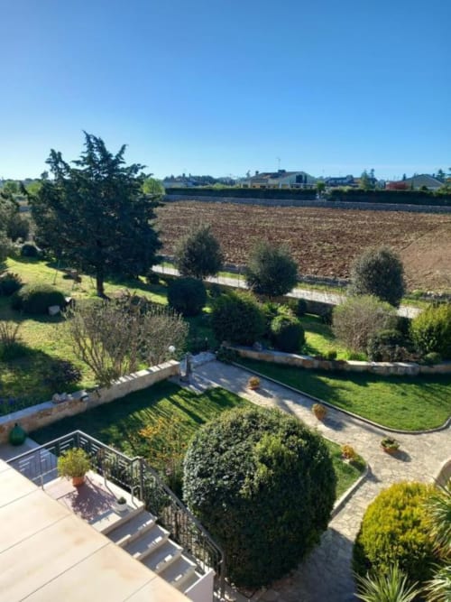 Villa Ribes AgriBio: vista sulla campagna con giardini curati, canali irrigui e campi ondulati ad Altamura, Italia