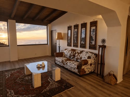 Quarto Limones no Jardines de Ifonche com sofá de couro, vista para o oceano, pisos de madeira e painéis asiáticos decorativos