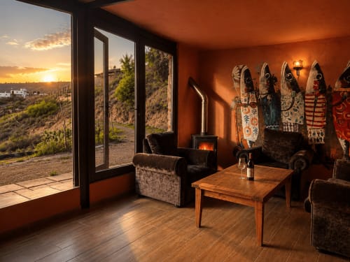 Sala aconchegante com lareira, vistas das montanhas ao pôr do sol e tapeçarias tradicionais em Jardines de Ifonche, Tenerife