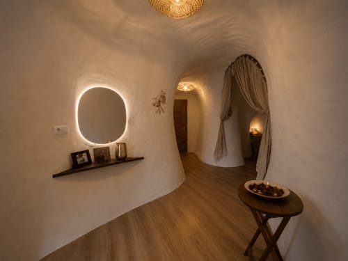 Banheiro moderno no quarto Granada do hotel Jardines de Ifonche com espelho oval iluminado, prateleira escura e pisos de madeira