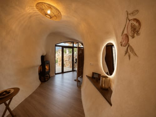 Corredor minimalista nos Jardines de Ifonche com paredes cor creme, pisos de madeira, espelho iluminado, luminária de teto tecida