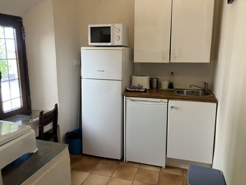 Pequeña cocina en villa Casa Zarcillo de Casa Rural La Navarra, con refrigerador, microondas, estufa y fregadero blancos