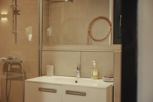 Modern bathroom at Mas Tihou Le Beausset with white vanity, mirror, shower, and toiletries in Le Mazet Tihou room