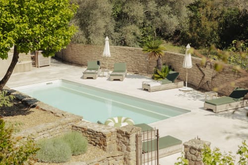Rectangular pool with loungers and white umbrellas in the garden at Mas Tihou, Le Beausset