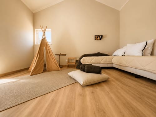 Suíte de quarto espaçoso na Quinta Do Carril com tenda indígena de madeira, roupa de cama branca, almofadas e iluminação acolhedora em Portugal