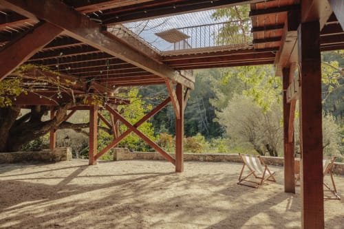 Shaded terrace at Mas Tihou B&B in Le Beausset with wooden pergola, deck chairs, and forest views