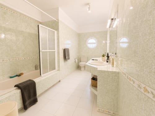 Casa de banho elegante no Quarto Simão da Quinta Do Carril, Portugal, com azulejos bege, lavatório duplo e chuveiro integrado