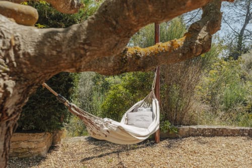 White hammock hanging from rustic wooden beam in garden at Mas Tihou B&B, Le Beausset