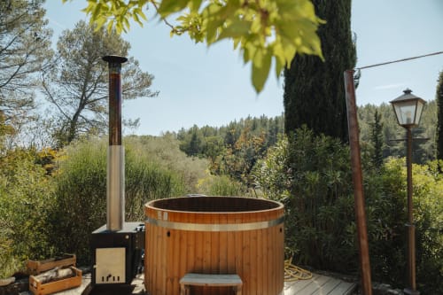 Wooden hot tub with chimney at Mas Tihou B&B in Le Beausset, surrounded by garden and forest views