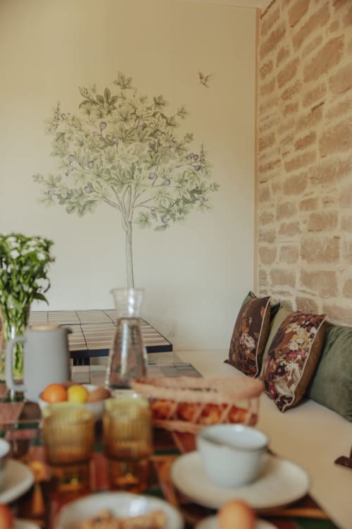 Dining area at Mas Tihou with botanical wall art, set table, brick walls, and garden views in Le Beausset