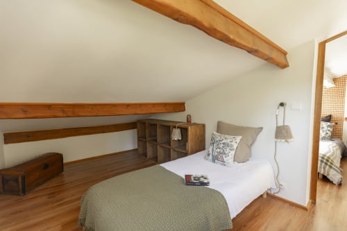 Chambre cosy du Mas Tihou avec poutres en bois, draps blancs et vue sur le jardin à Le Beausset
