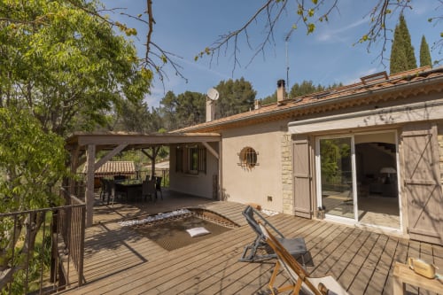 Terrasse du gîte Mas Tihou avec transats, espace repas, pergola et vue sur le jardin à Le Beausset