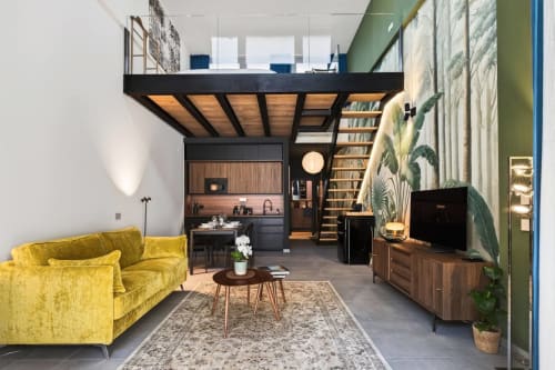 L'appartamento Loft Jenner Milano con divano giallo, camera in mezzanino, angolo cottura e piante tropicali
