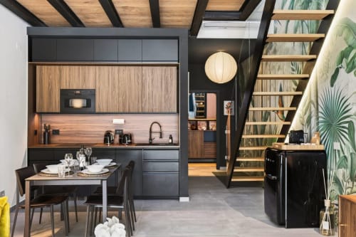 Moderno loft a Milano con cucina open-plan, mobili in legno, zona pranzo e scala in legno