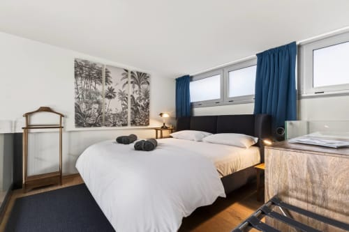Camera moderna a The Loft Jenner di Nestco a Milano con letto queen, tende blu e vista sul giardino da ampi finestre