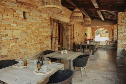 Salle à manger rustique en brique au gîte Mas Tihou du Beausset avec luminaires suspendus tissés et vue sur le jardin