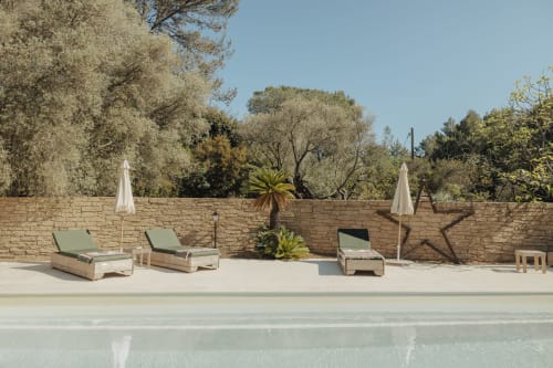 Terrasse au bord de la piscine de Mas Tihou avec chaises longues, parasols blancs et jardin méditerranéen à Le Beausset