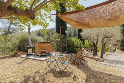 Terrasse extérieure du gîte Mas Tihou à Le Beausset avec bain à remous, salon de jardin et vue sur le jardin