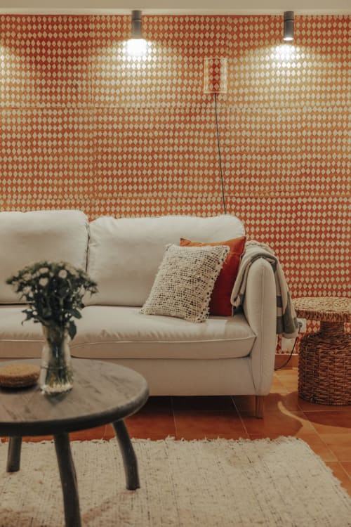 Salon douillet du gîte Mas Tihou avec canapé crème, papier peint à motifs et vue sur le jardin à Le Beausset