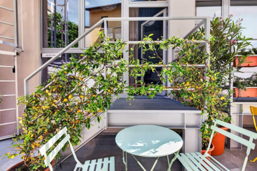 Il balcone The Loft Jenner a Milano con ringhiere ricoperte di edera, tavolo rotondo e vista sul giardino