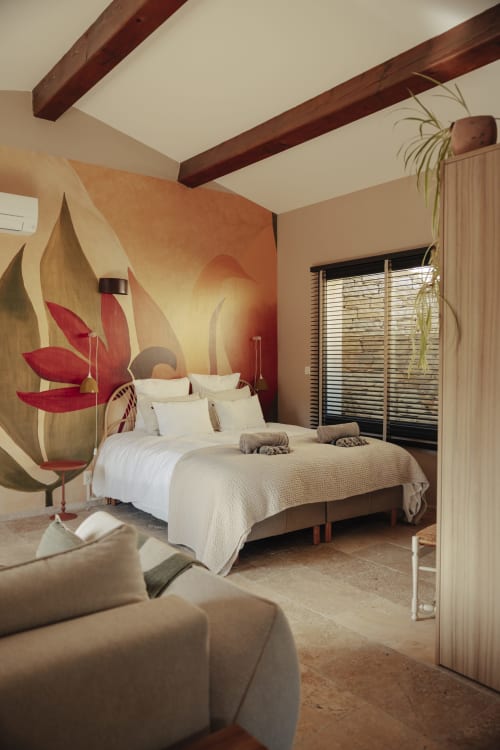 Chambre élégante du gîte Mas Tihou avec art floral, poutres en bois et vue sur le jardin à Le Beausset