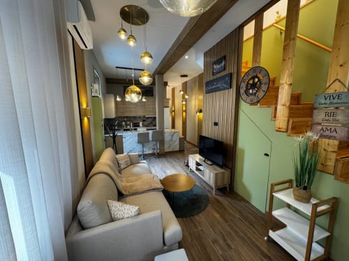 Sala de estar moderna da villa Antas Family Retreat em Vila Nova de Gaia com sofá bege, luminárias, cozinha e vista da cidade