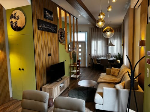 Sala de estar moderna na villa Antas Family Retreat com acentos amarelos, luminárias suspensas, assentos confortáveis e vista da cidade