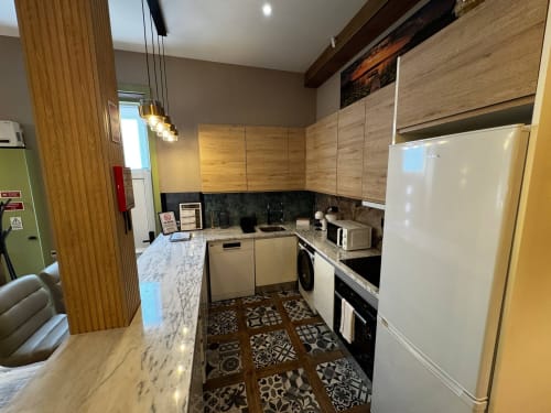 Cozinha moderna na vila Antas Family Retreat, Vila Nova de Gaia, com armários de madeira, bancadas em mármore e aço inoxidável
