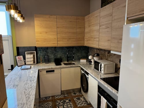 Cozinha moderna na villa Antas Family Retreat, Vila Nova de Gaia com armários em madeira, bancadas em mármore e aço inoxidável