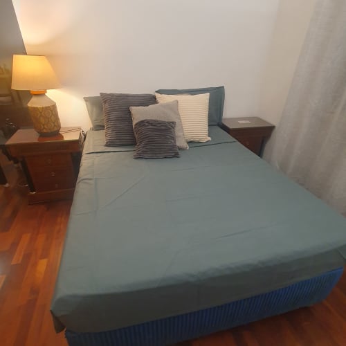 Camera da letto accogliente dell'appartamento Myob a Santa Andrea La Storta con biancheria blu, cuscini rigati, comodini in legno e tavolo