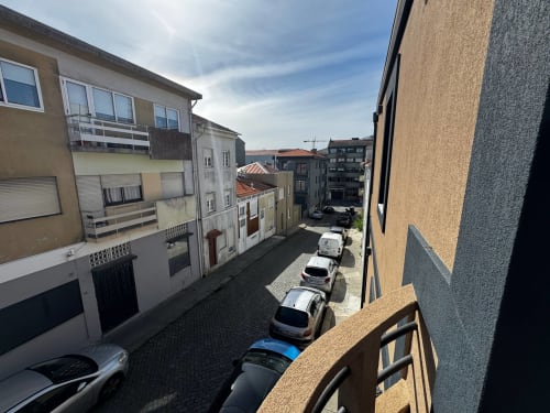 Vista da rua da vila de Amber Star Rent em Vila Nova de Gaia com carros estacionados e edifícios residenciais