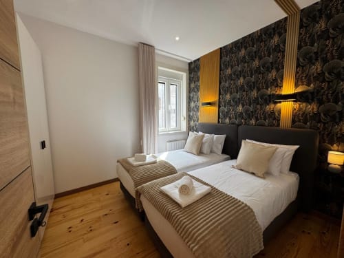 Quarto moderno na Amber Star Rent's Antas Family Retreat em Vila Nova de Gaia com camas geminadas, papel de parede com padrão escuro e