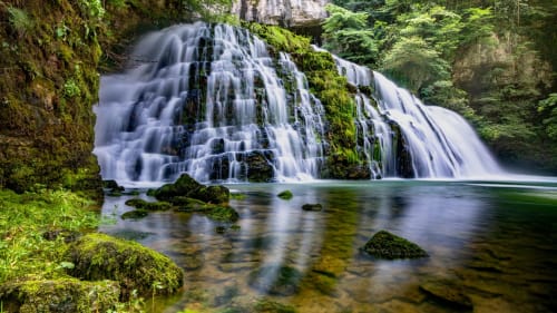 Cascade entourée de mousse luxuriante et forêt verdoyante à Vallée du Lison, près du gîte La R'Mise de Surcey, France