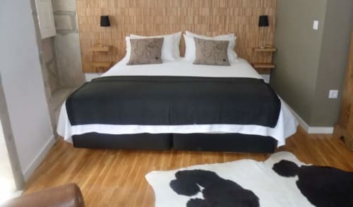 Quarto do estúdio PortoSense Ribeira com vista para o rio, cama com lençol branco e passadeira preta, cabeceira de madeira
