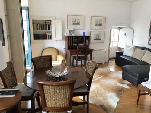 Duplex PortoSense na Ribeira: sala de estar com mesa redonda, assentos, estante e vista para o rio