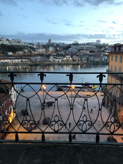 Varanda ornamentada com vista para a Ribeira do Porto, rio Douro e paisagem urbana ao entardecer do apartamento PortoSense