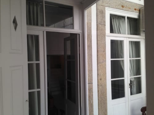 Interior do apartamento PortoSense Almada com portas e janelas de moldura branca abrindo para área de pátio no Porto