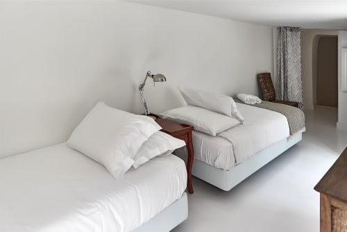 Camas de casal modernas com roupa branca no apartamento PortoSense Almada no Porto, com luminária de cabeceira e decoração neutra
