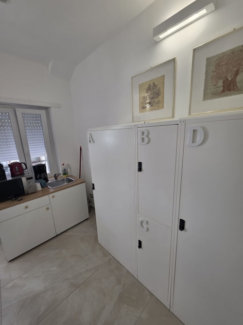 Bagno moderno con camere contrassegnate A, B, D presso bed and breakfast in Vaticano Roma, dotato di angolo cottura e opere d'arte incorniciate