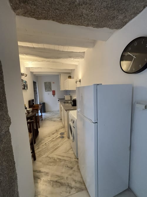 Cozinha moderna com eletrodomésticos brancos, bancada de granito e serviços de lavanderia no apartamento PortoSense Almada no Porto