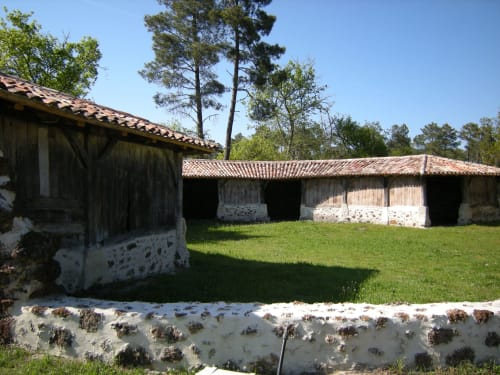 Bâtiments en pierre traditionnels aux toits en terre cuite de la Maison d'hôtes Les Gravets, guesthouse rustique à Sigalens, France