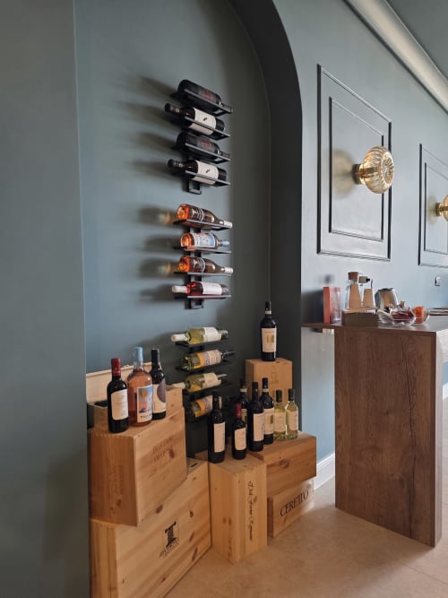Zona degustazione vini presso Via del Mare Apulia B&B a Rutigliano, con bottiglie a parete e cassette di legno