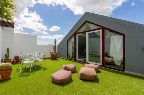 Modern rooftop terrace at Lisbon Poets Inn, seating areas, and city views