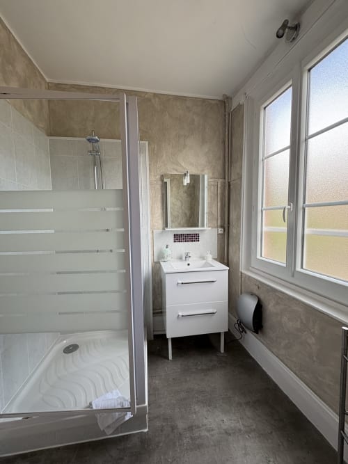Salle de bain moderne à la Villa Aliénor B&B aux Andelys avec douche, vasque blanche et grandes fenêtres
