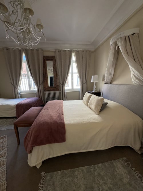 Suite Confort élégante à la Villa Aliénor aux Andelys avec lit à baldaquin, lustre et vue sur la ville