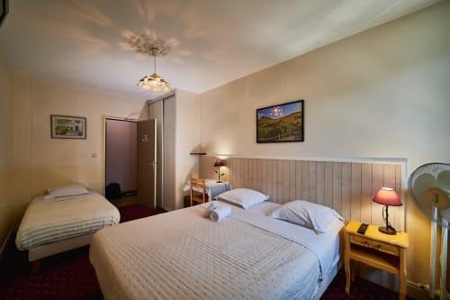 Triple bedroom at La Caravelle hotel in Riom with double bed, single bed, and modern amenities