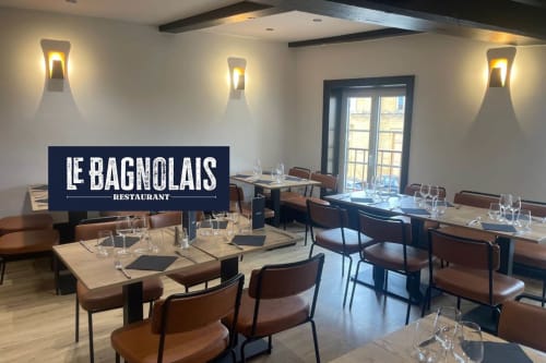 Le Bagnolais Restaurant dining room with wooden tables, brown leather chairs, and elegant wall sconces at Le Clos Des Anges,
