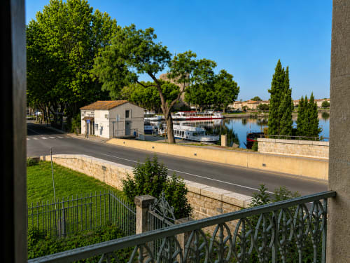 Aigues-Mortes waterfront view from Le Palmier hotel balcony with moored boats and cypress trees